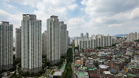 부동산 시장 자산 양극화를 상징하는 신축 고층 아파트와 노후 주거지의 대조적인 도시 풍경